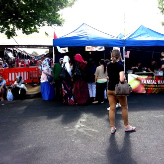 Women visit a food stall at the Malaysian Street Festival 2014