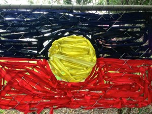 Aboriginal flag drawn over a fence